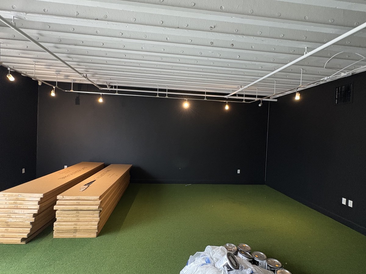 Before: empty commercial space with framing materials staged on the floor