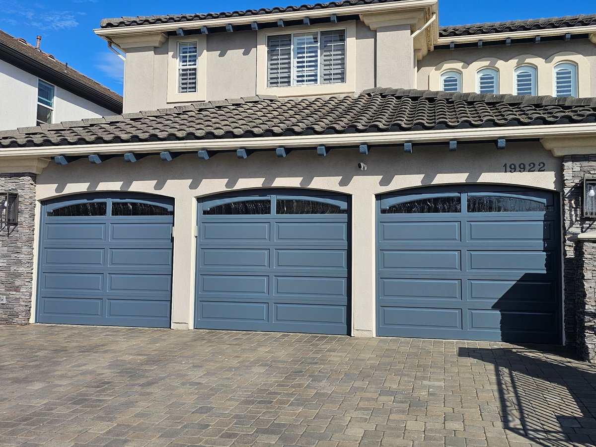 Garage doors freshly repainted in a soft blue-gray finish