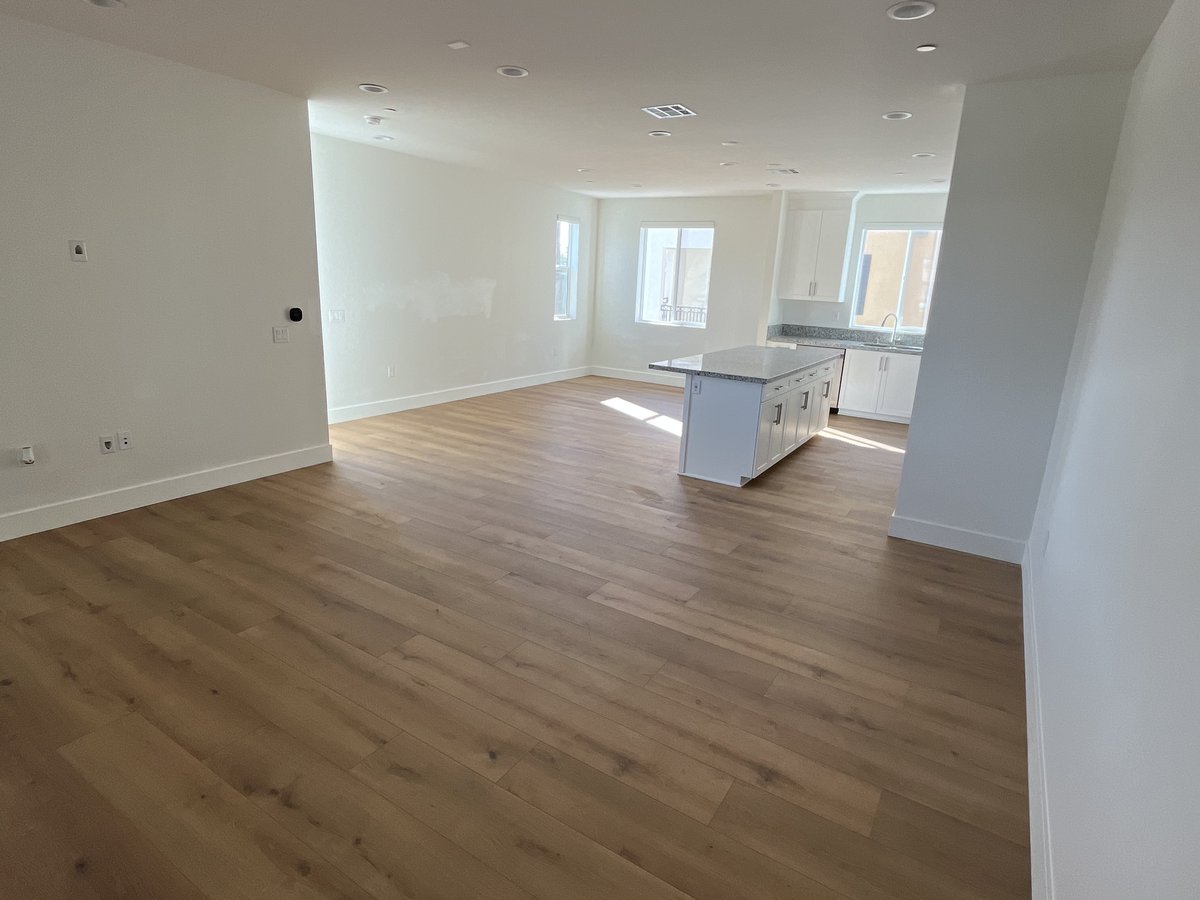New wood-look flooring installed in a living room and kitchen