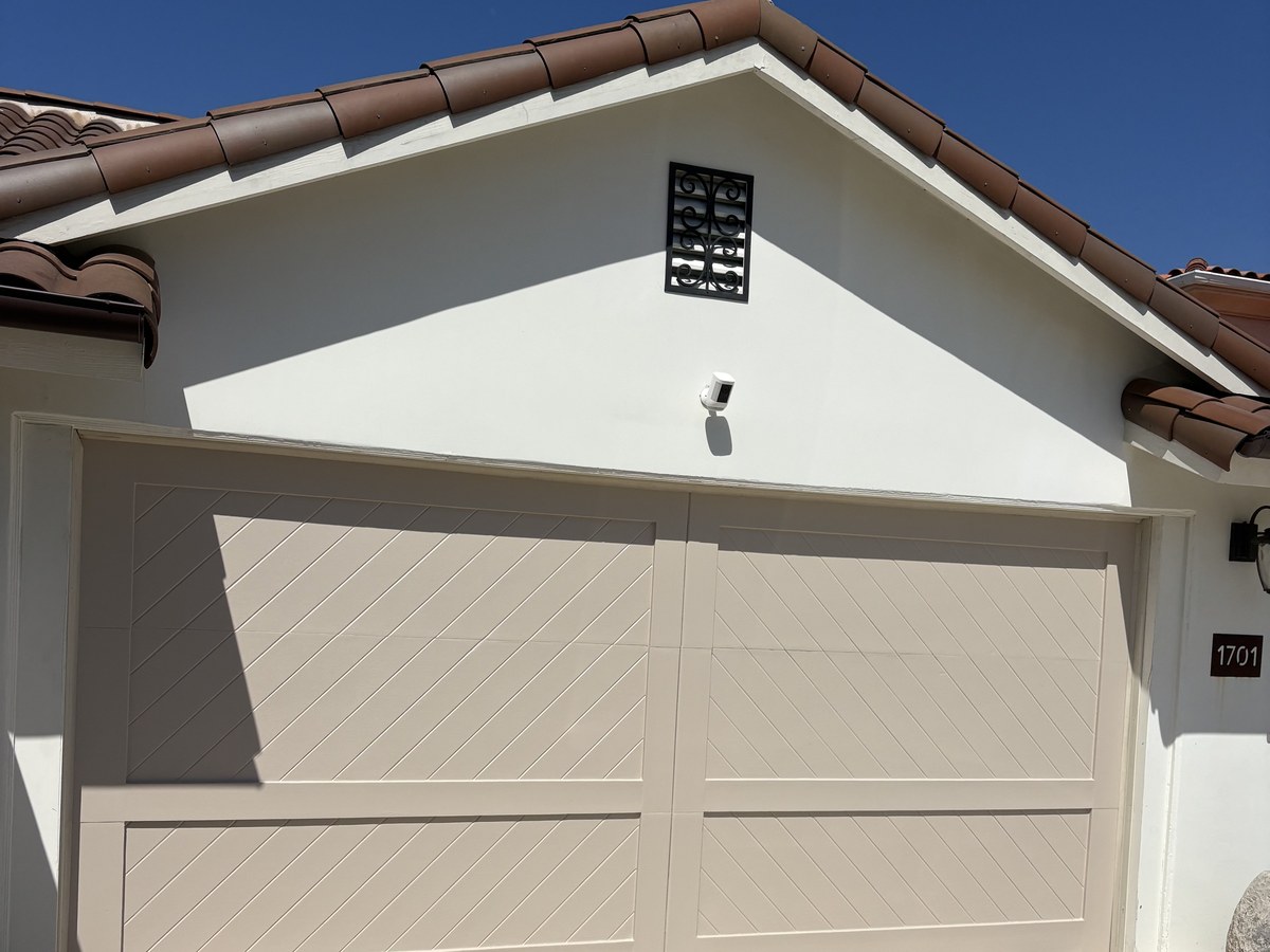 After: garage doors repainted in a soft blue-gray finish