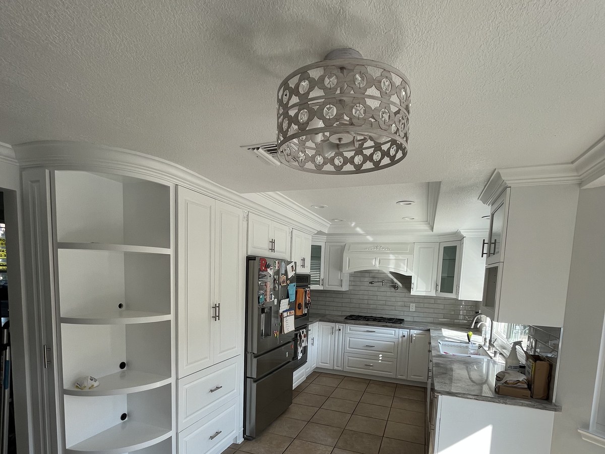 Kitchen with cabinets refinished in a soft blue-gray and a new tile backsplash